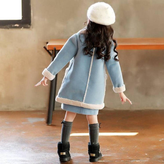 Girls in cozy blue winter coats with faux fur trim, matching hats, and black boots