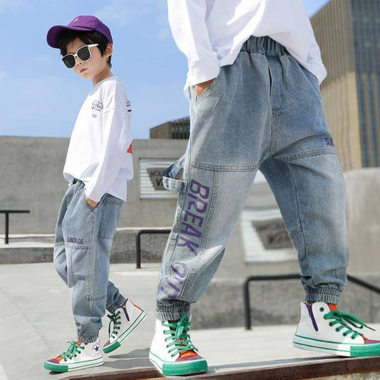 Boys' loose Western style jeans and trousers for primary school students by Ancient Energy, shown in a casual school outfit.