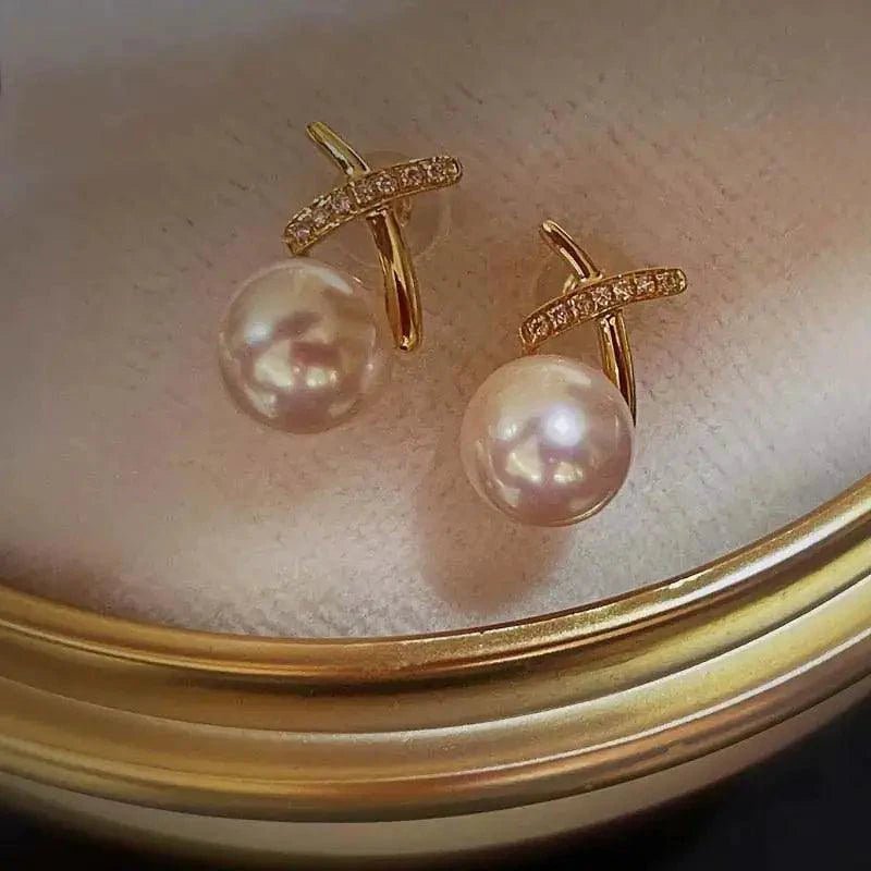 18K gold pearl stud earrings by MANDOTOS featuring elegant round pearls on simple gold posts.
