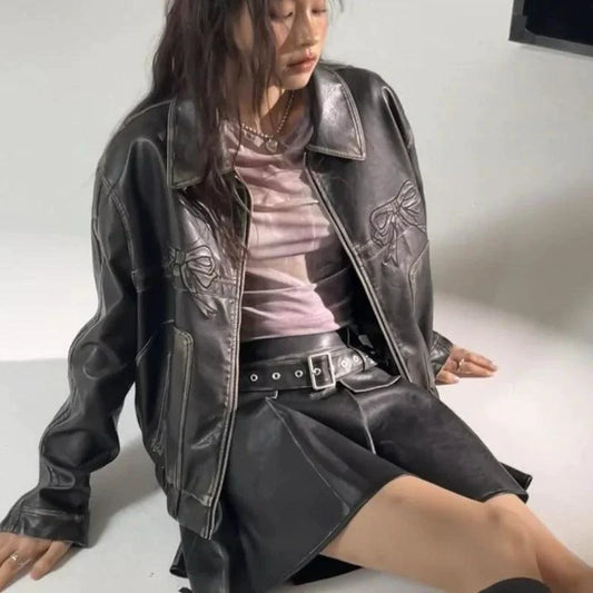 Mandotos Bow Biker's Leather Jacket displayed on a hanger, featuring a sleek black design with bow accents on the collar.