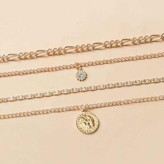 Mandotos gold layered necklace with coin pendant and sun charm, stylish jewelry for women featuring bold, chunky design.
