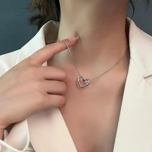 Stainless steel twist hollow heart necklace on a clavicle chain, featuring a sleek, modern design by MANDOTOS.