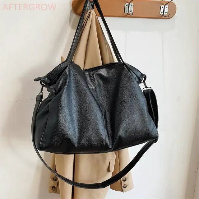 Elegant leather carryall bag by MANDOTOS featuring sleek design, sturdy handles, and spacious interior for versatile use.