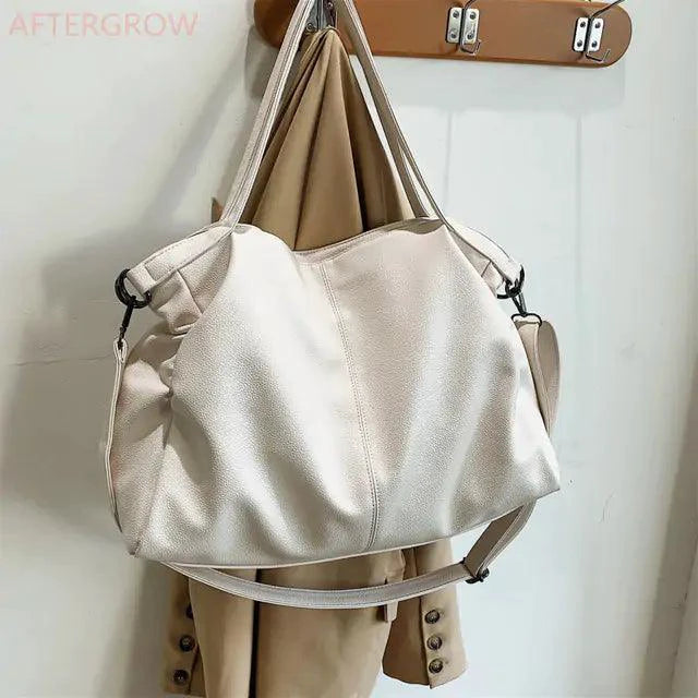 Elegant leather carryall bag by MANDOTOS, featuring sleek design and sturdy handles for versatile everyday use.
