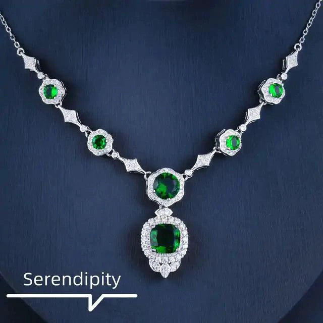 Emerald Elegance white gold necklace by MANDOTOS featuring a central emerald gemstone and delicate chain design.