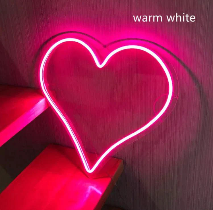 Pink Heart Glow LED Neon Light by MANDOTOS illuminated with a glowing pink heart shape on a dark background.
