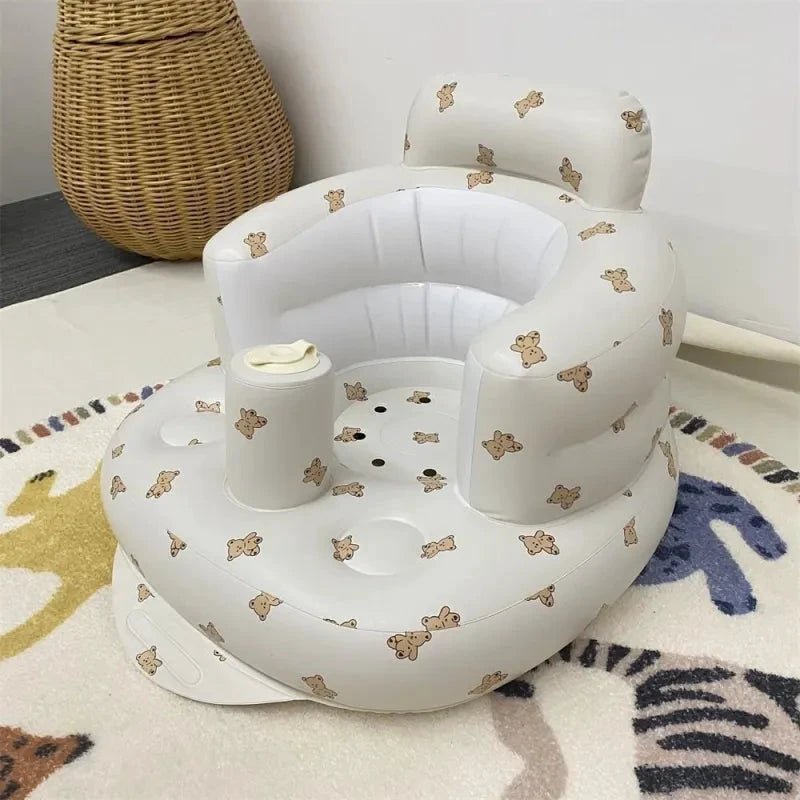 Inflatable baby chair by MANDOTOS designed for dining and bath, featuring a soft, cushioned seat with safety straps.