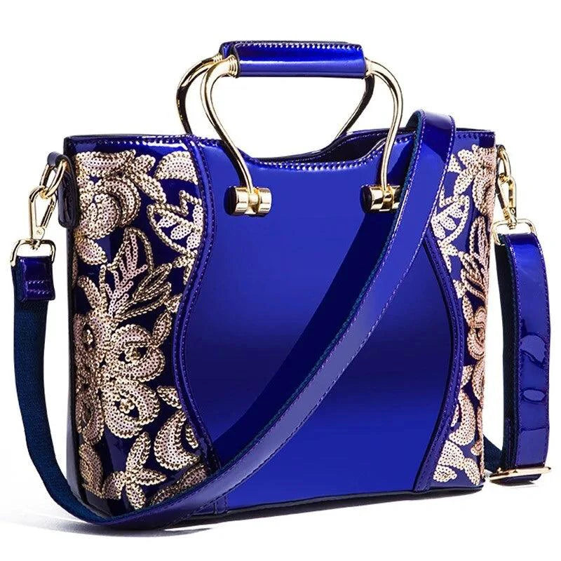 Mandotos elegant floral leather tote bag in burgundy with embroidered floral design and an adjustable crossbody strap.