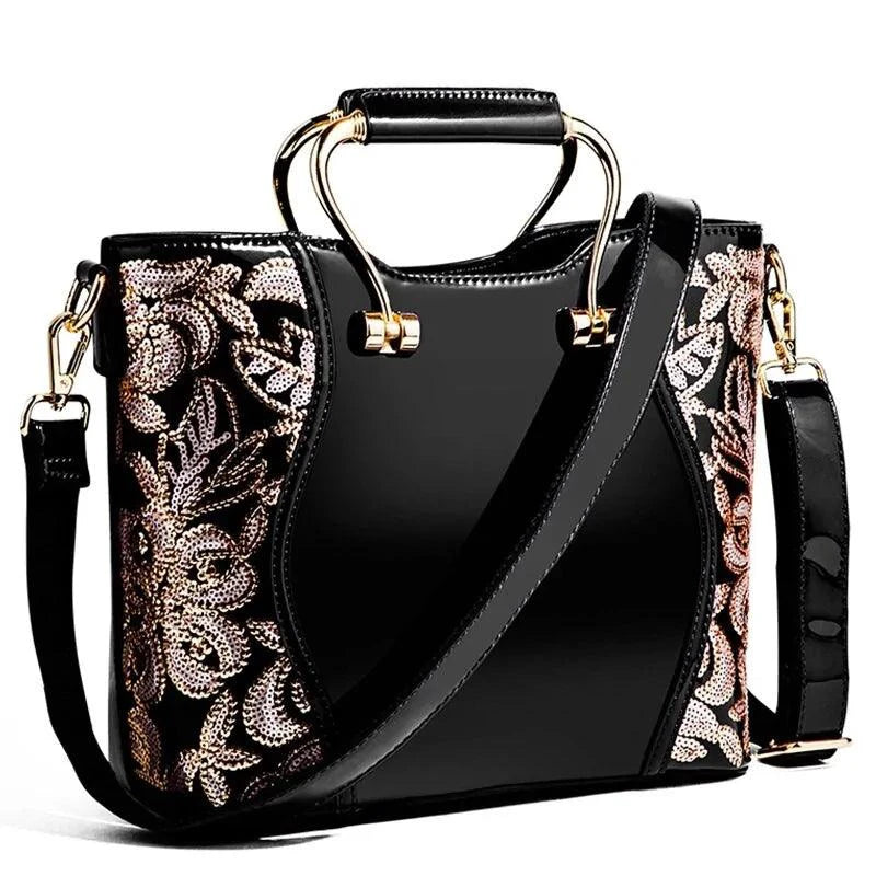 Mandotos elegant floral leather tote bag in burgundy with embroidered details and a removable crossbody strap.