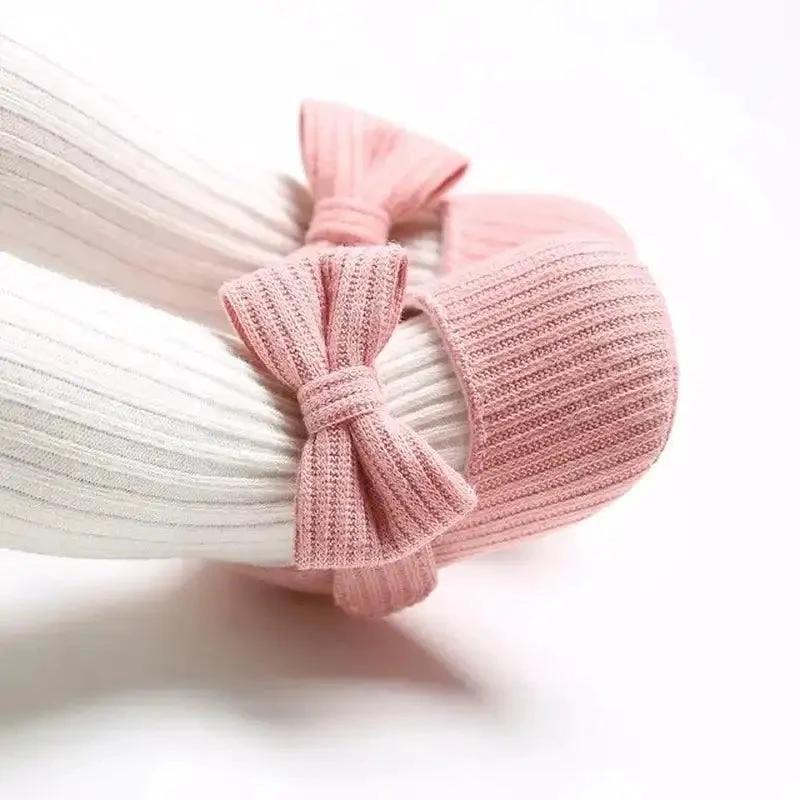 Soft newborn shoes by MANDOTOS, featuring cozy fabric and gentle sole for delicate baby feet.