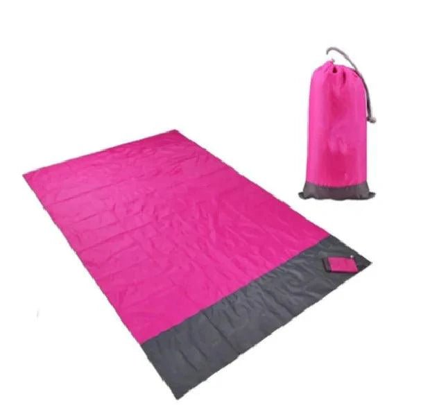 Mandotos sandproof portable beach mat spread out on sandy shore, lightweight and easy to carry for outdoor beach trips.