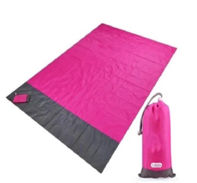 Mandotos sandproof portable beach mat spread out on sandy shore, lightweight and durable for outdoor beach outings.