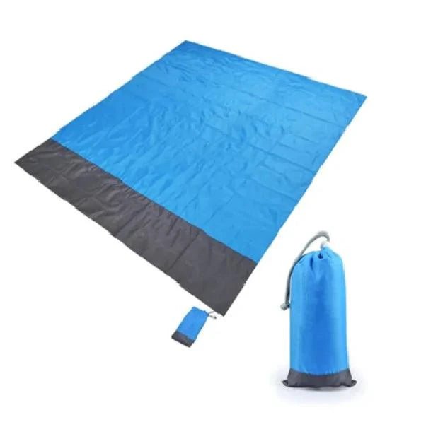 Mandotos sandproof portable beach mat spread out on sandy shore, lightweight and easy to carry for outdoor beach relaxation.