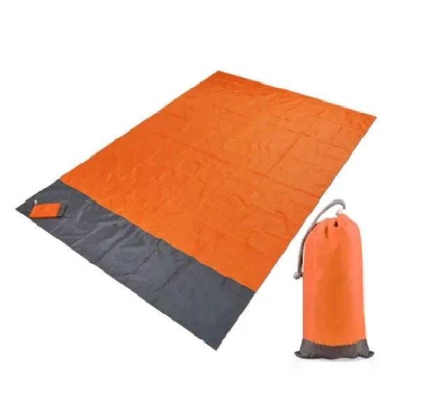 Mandotos sandproof portable beach mat spread out on sandy shore, lightweight and easy to carry for beach outings.