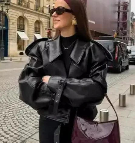 Mandotos sleek matte leather coat with a smooth finish and tailored fit, displayed on a hanger in a minimalist setting.