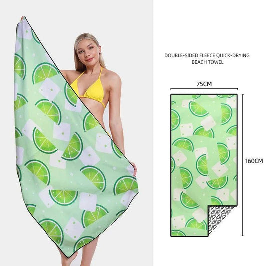 Mandotos SwiftDry patterned beach towel with colorful geometric design laid flat on sand.