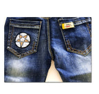 Blue denim jeans with star patch and yellow brand tag on back pockets, fashion apparel