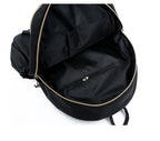 Black backpack interior with gold zipper and front pocket, ideal for fashion accessories and daily essentials