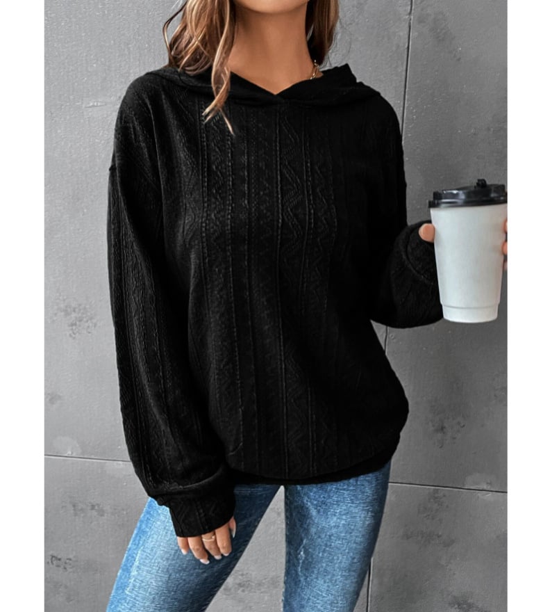 Woman wearing a black Mandotos International autumn casual solid hoodie and blue jeans.
