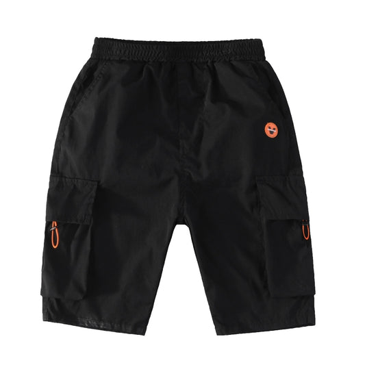 Black cargo shorts with smiley patch, worn with white sneakers and orange tee for kids' casual fashion