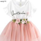 Girls' white V-neck dress with pink tulle skirt, floral embroidery, and 'Canterbury' script