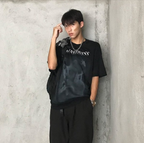 Man wearing Mandotos International Urban Graffiti Print Tee and black trousers.