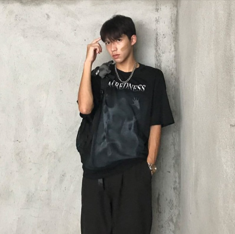Man wearing Mandotos International Urban Graffiti Print Tee and black trousers.