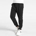 Boy wearing Ancient Energy boys' sports trousers, lightweight athletic pants with elastic waistband and sporty design.