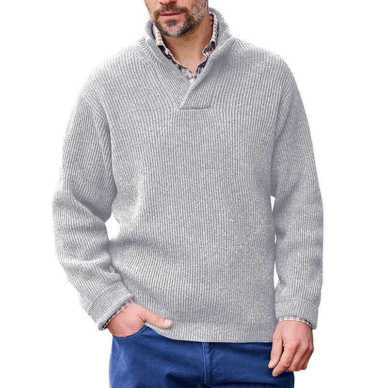 Man wearing a light grey Mandotos International high neck classic ribbed sweater and blue pants.
