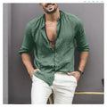 Man wearing a Mandotos International green classic buttoned collar shirt and white trousers.