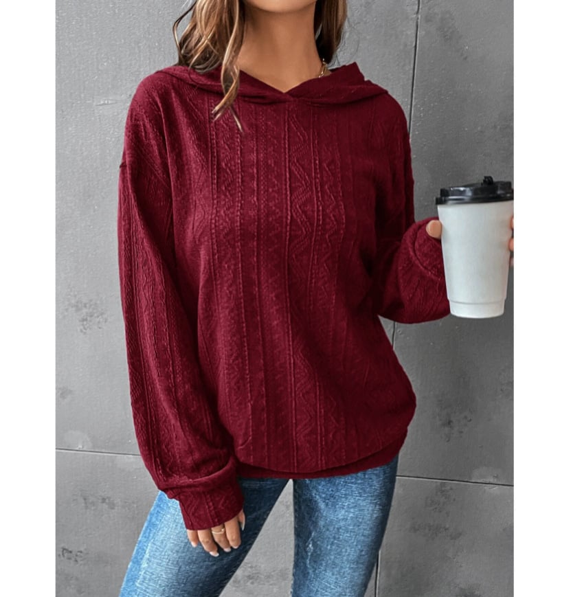 Woman wearing a Mandotos International burgundy autumn casual solid textured hoodie and blue jeans.