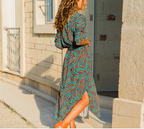 Woman wearing a chic V-neck high-waist printed dress with a teal and orange pattern.