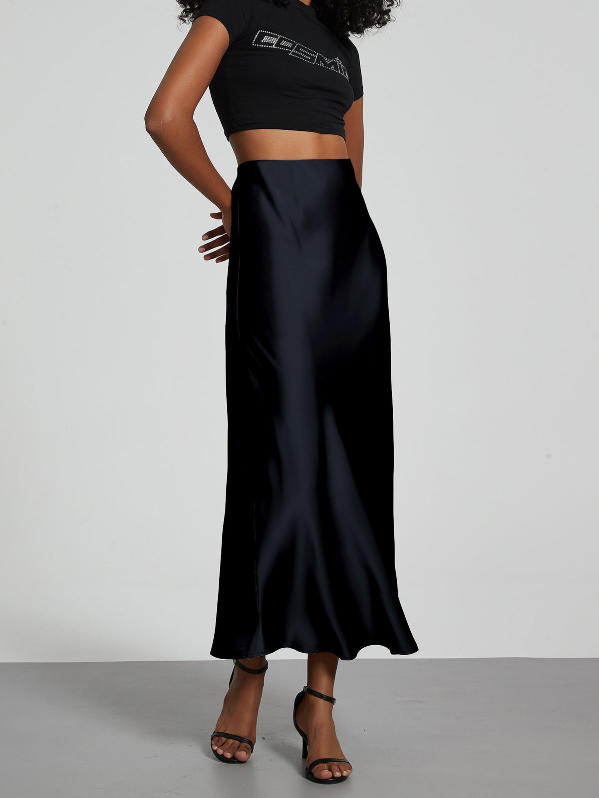 Elegant black satin midi skirt with a slim, flowy silhouette.