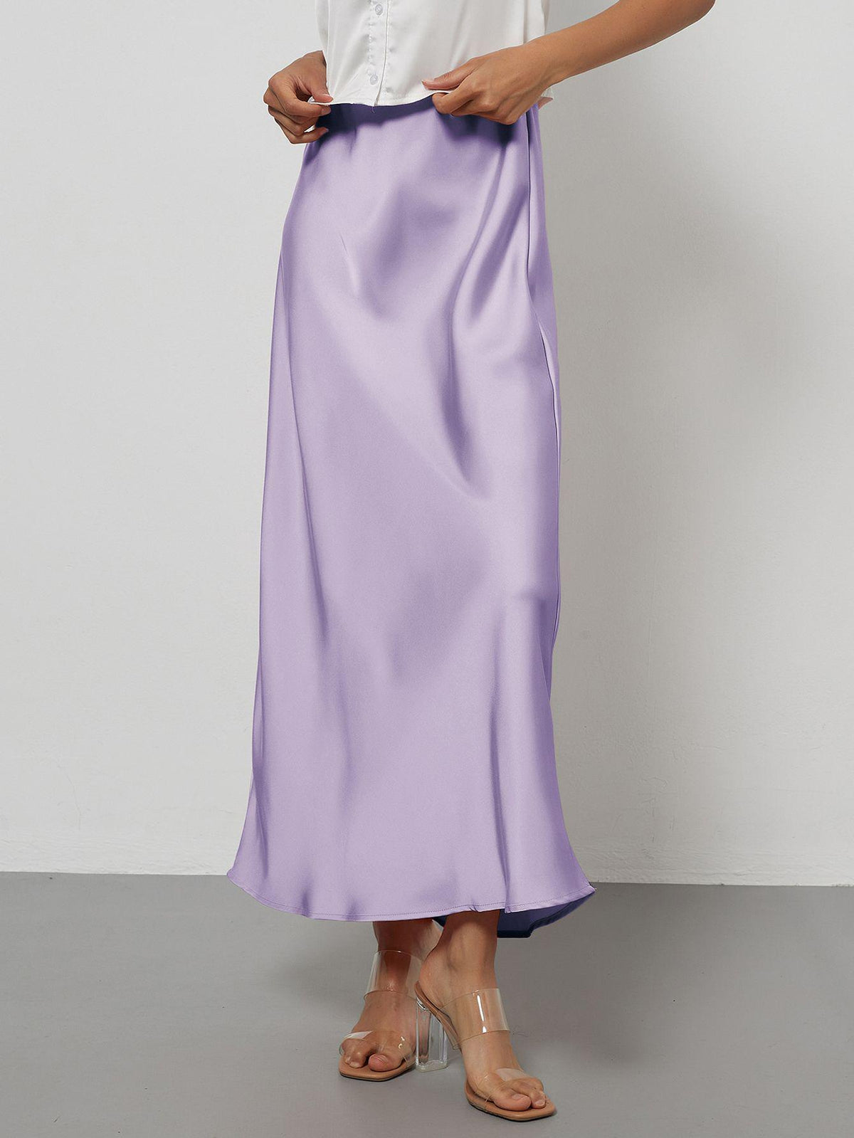 Elegant lavender satin midi skirt with a slim flowy fit worn by a model.