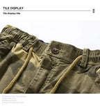 Close-up of men's camouflage outdoor cargo shorts with drawstring waist and button closure.