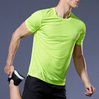 Man wearing a lime green quick dry compression running shirt and black shorts during fitness workout