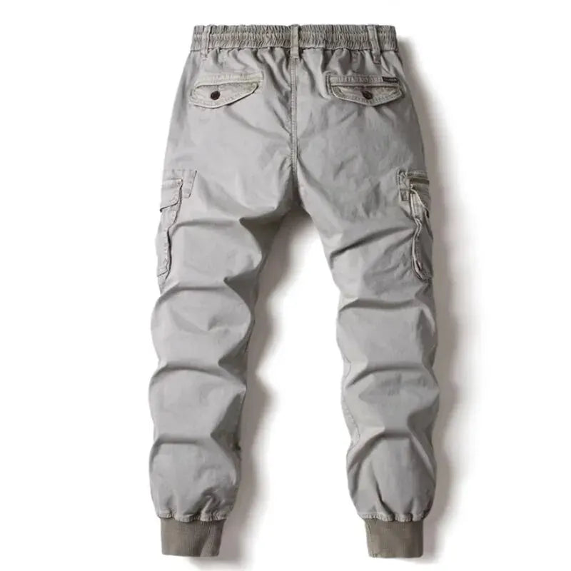 Grey cotton cargo pants for men featuring tactical military pockets and elastic jogger cuffs.