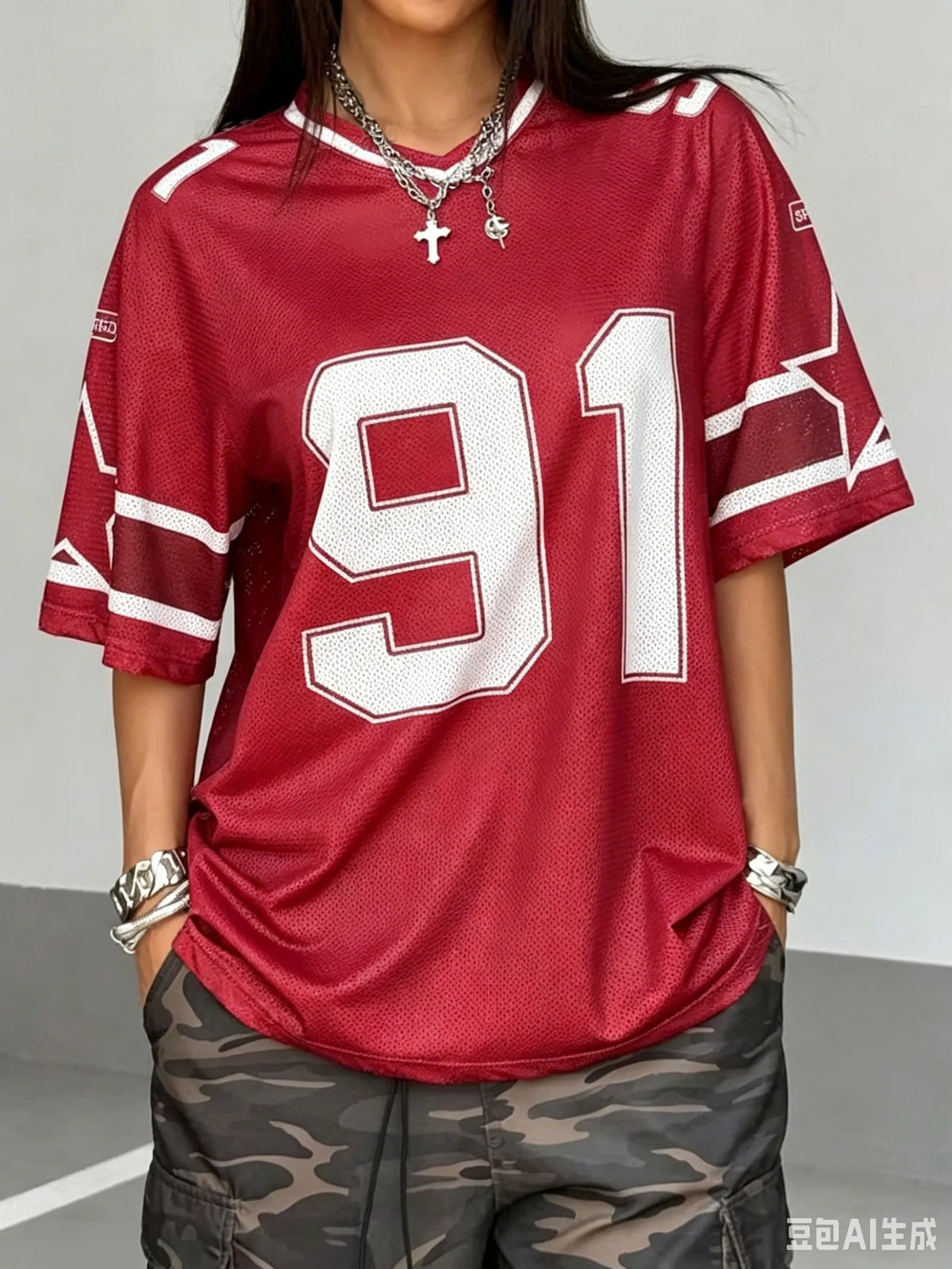 Woman wearing a red Mandotos International oversized jersey with white number 91 print and camo pants.