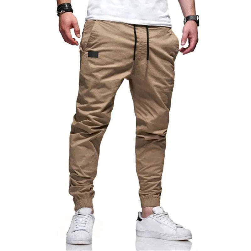 Man wearing Mandotos International casual khaki jogger cargo pants and white sneakers.