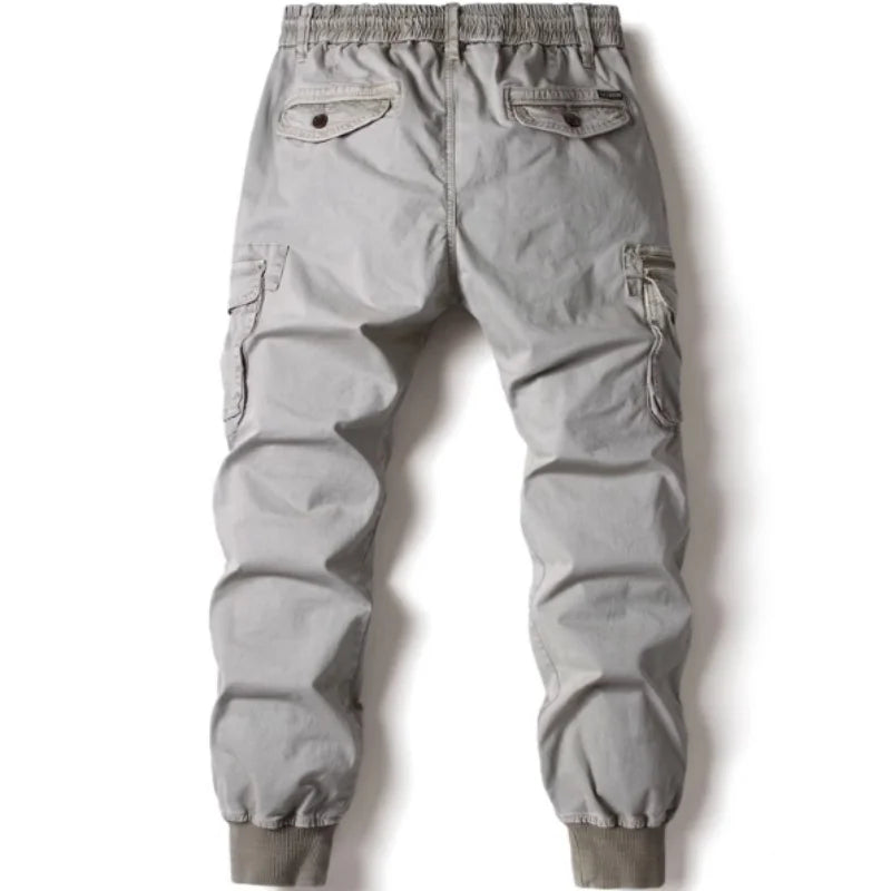 Grey cotton cargo pants for men featuring tactical pockets and elastic jogger cuffs.