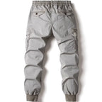 Grey cotton cargo pants for men featuring tactical pockets and elastic jogger cuffs.