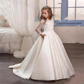 Little girl wearing a champagne-colored long sleeve dress by Ancient Energy, featuring soft fabric and elegant design.