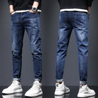 Men's ripped denim jeans with cat-whisker scratches from Ancient Energy, showcasing distressed denim style and casual fit.
