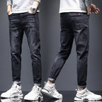 Men's ripped denim jeans with cat-whisker scratches by Ancient Energy, showing distressed denim with stylish, intentional tears and scratches.