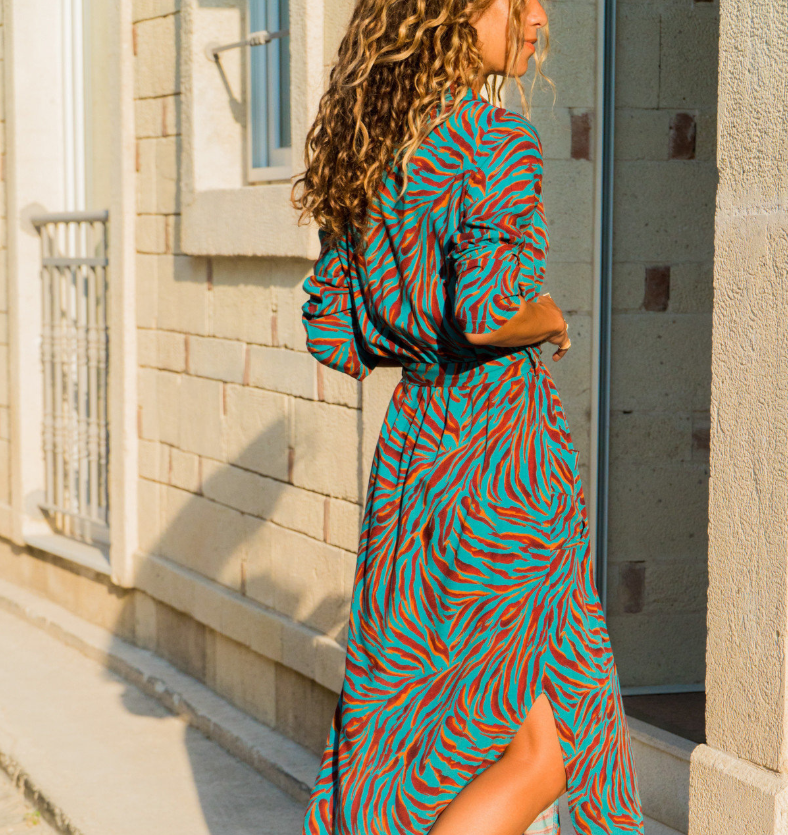Woman wearing a Mandotos International chic V-neck high-waist printed dress in teal and orange.
