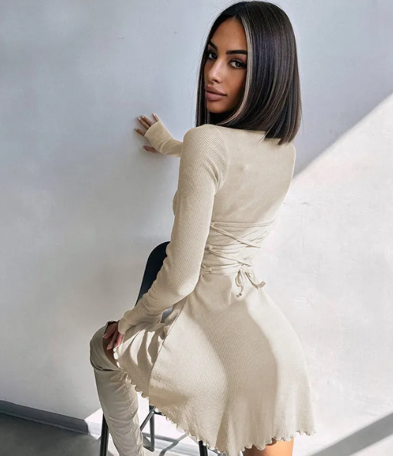 Woman wearing a beige ribbed Tie Waist Pullover Dress by Mandotos International.
