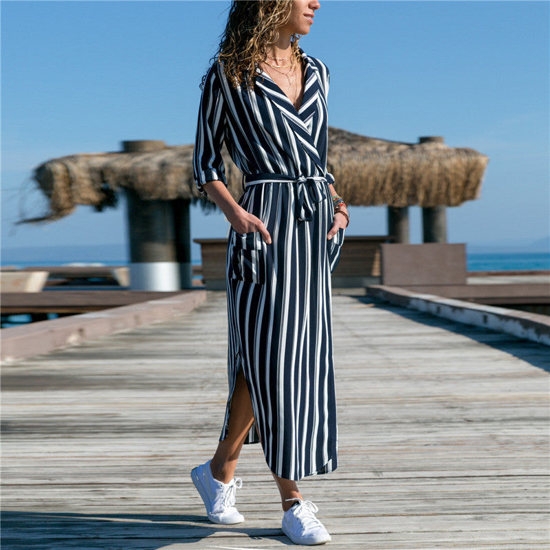 Woman wearing a chic V-neck high-waist printed dress with vertical stripes by Mandotos International