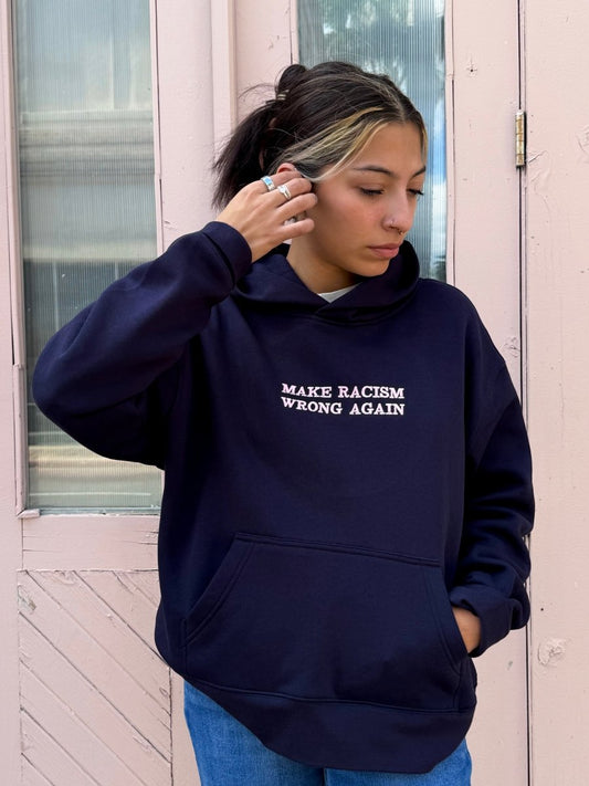 Navy sweatshirt by JZD with anti-racism message, featuring a comfortable fit and bold print on the front.