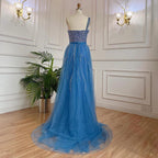 Blue handmade beaded split shoulder fishtail dress by MANDOTOS, showcasing intricate beadwork and elegant design.