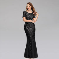 Elegant black evening dress by MANDOTOS featuring a floor-length design and subtle satin finish.